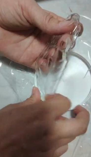 IAS-SDC-50 strippable decontamination film peel demonstration — hands peeling transparent polymer film from substrate, showing tensile integrity and clean substrate release